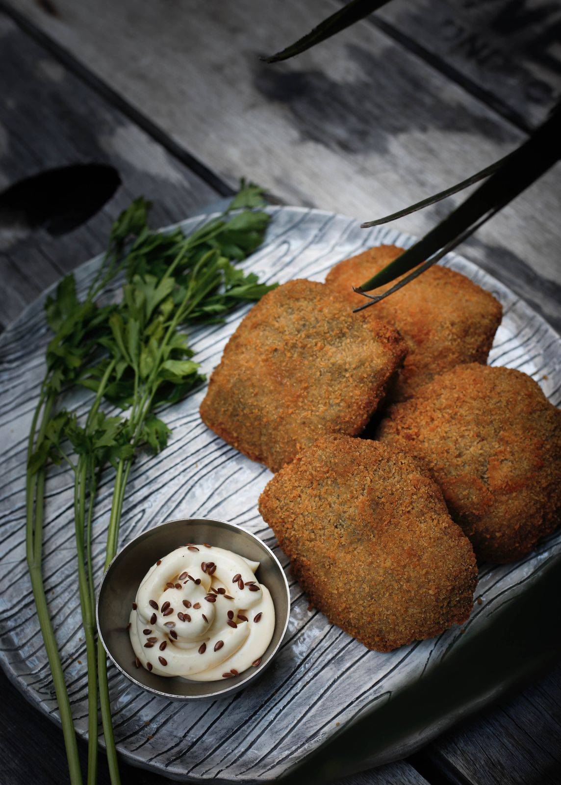 Venaggets de tofu dorados con un dip y perejil